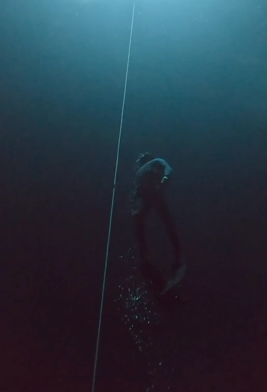 Apneísta descendiendo en aguas profundas